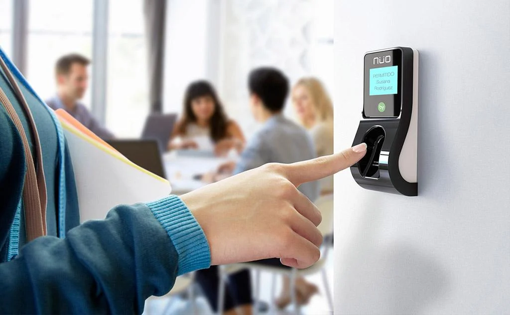 Persona utilizando un lector biométrico para acceder a una oficina